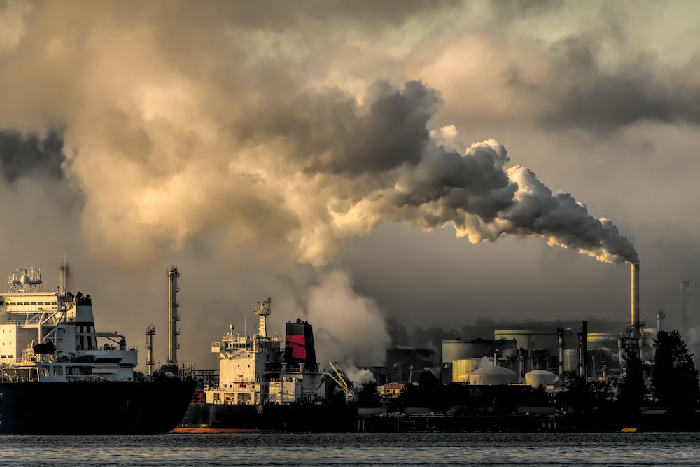 arkened clouds of smoke polluting the environment above a refinery.